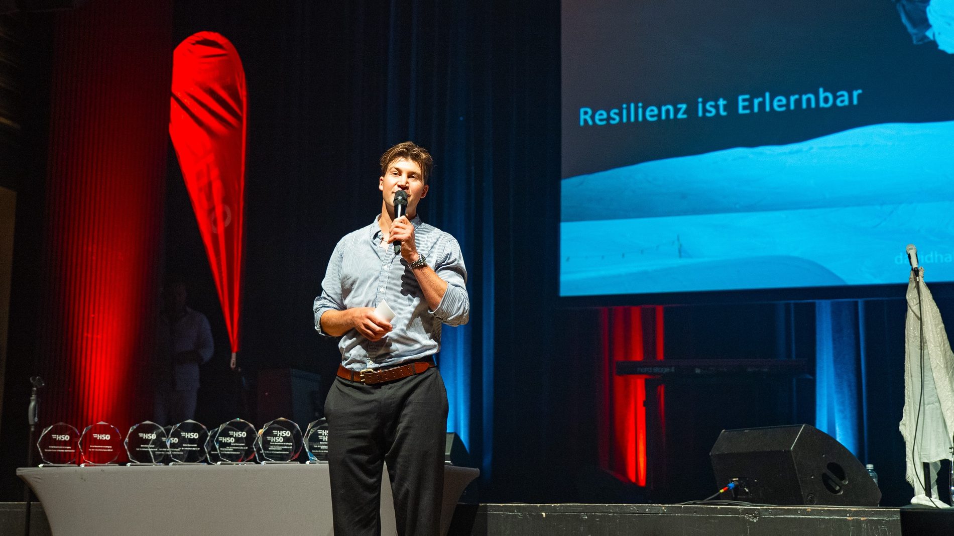 David Hablützel auf der Bühne, im Hintergrund die Folie «Resilienz ist Erlernbar»